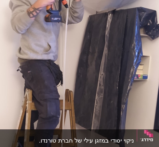 אדם מנקה מזגן עם מכונת שטיפה